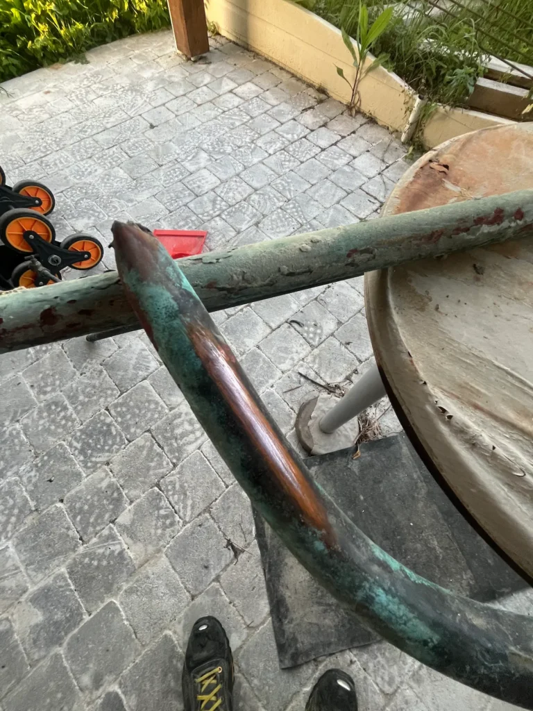 Canalisation en cuivre présentant une trace d’oxydation caractéristique — corrosion par l'acidité et l'electrolyse, microfissure visible, oxydation par strates